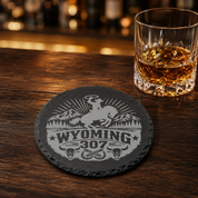 Wyoming 307 Engraved Slate Coaster SetEngraved Slate Coaster Set | Wyoming Cowboys | Drink Coaster | Table Decor — Dandelion Design Co. — SlateStudioMedia:gallery:9 — 0105-W3GN_wyoming_307_engraved_slate_coaster_setengraved_slate_coaster_set_wyoming_cowboys_drink_coaster_table_decor_08_round_whiskey_lifestyle.png