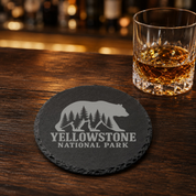 Yellowstone National Park Slate Coaster – Natural Stone Drink Coaster with Bear and Trees | Rustic Home Decor | Gift for National Parks — Dandelion Design Co. — SlateStudioMedia:gallery:9 — 0111-YNGN_yellowstone_national_park_slate_coaster_natural_stone_drink_coaster_with_bear_and_trees_rustic_home_decor_gift_for_national_parks_08_round_whiskey_lifestyle.png